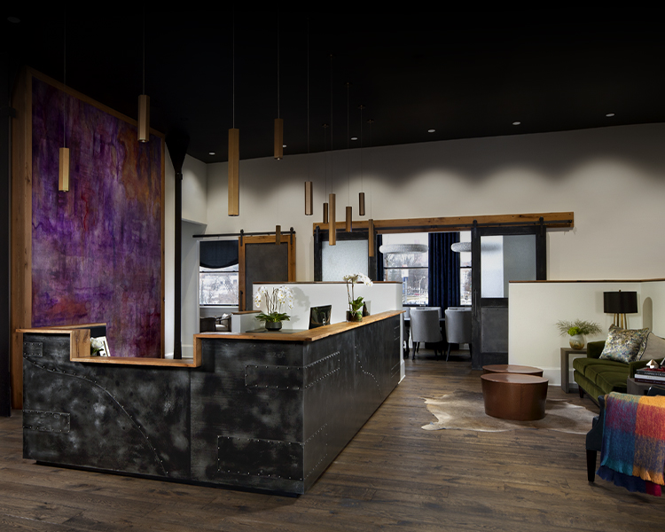 A sleek and modern office reception area featuring industrial-style design elements, warm wooden accents, and vibrant decor, representing a professional and welcoming environment for discussing the firm’s diverse practice areas.